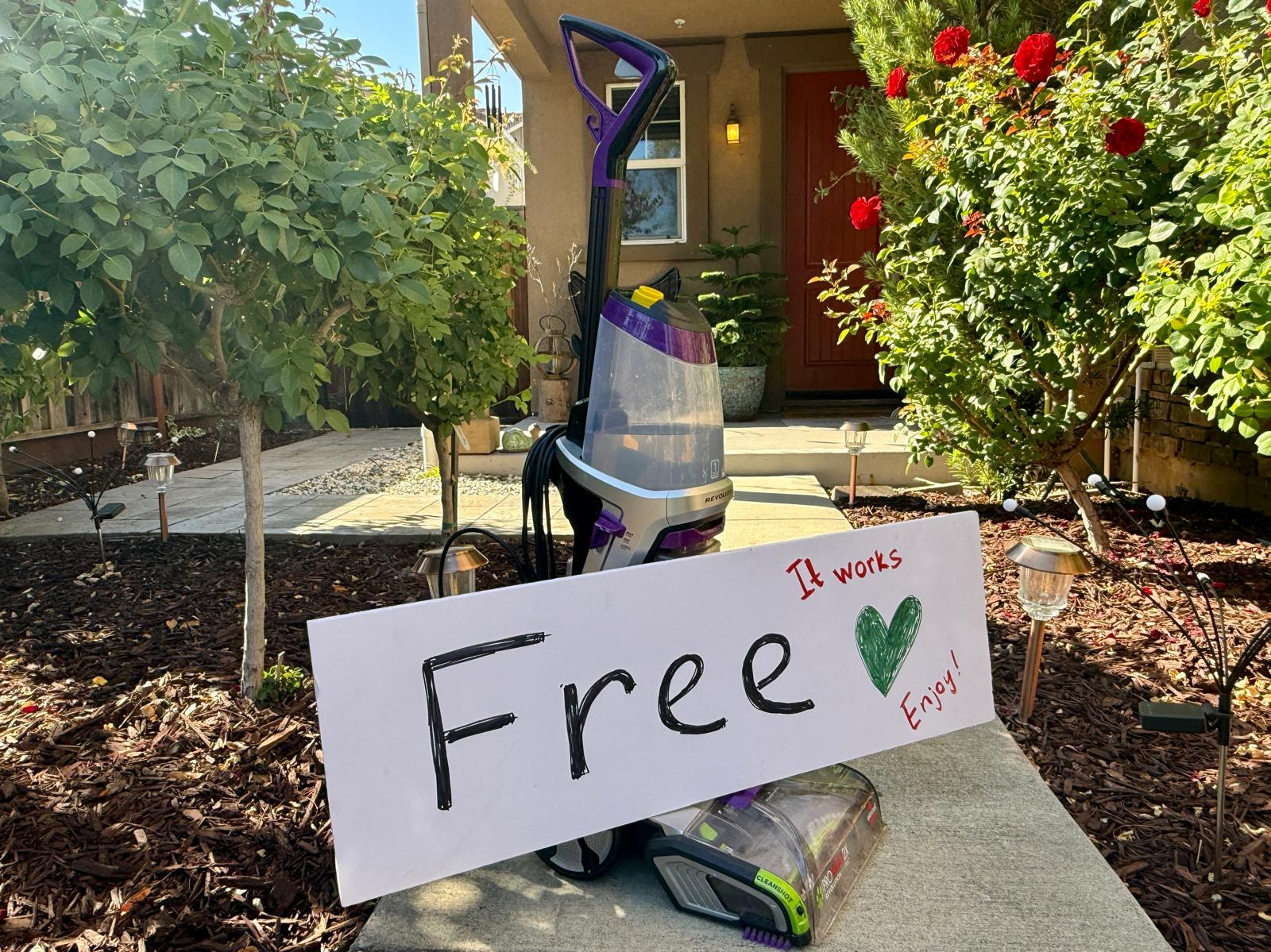 A free BISSELL carpet cleaner on a neighbor's porch with a handwritten 'Free, it works, enjoy' sign